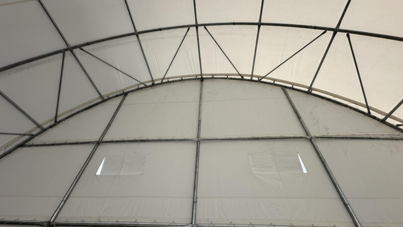 Shipping container domes shelter full length end wall.