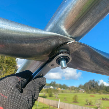 Securing the purlin and roof arch together using a ratchet spanner.