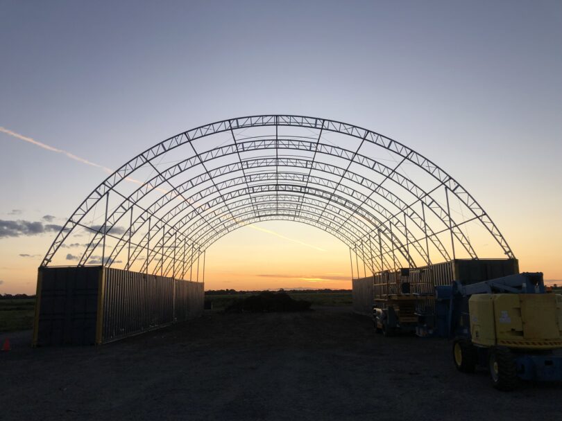 Shipping container dome shelter frame. Double truss sunset background. Quality Domes Direct.